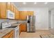 Well-equipped kitchen with stainless steel refrigerator, white appliances, and granite countertops at 604 Cheviot Ct, Apopka, FL 32712