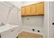 Bright laundry room with overhead cabinets, utility sink, and washer/dryer hookups at 604 Cheviot Ct, Apopka, FL 32712