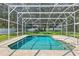 Sparkling screened-in pool with brick surround and lush landscaping at 604 Cheviot Ct, Apopka, FL 32712