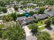 A bird's eye view showing a well-kept property with lush landscaping and a large driveway at 676 Dunblane Dr, Winter Park, FL 32792