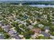 Aerial view showcases the neighborhood, mature trees, and proximity to a lake and the city skyline at 676 Dunblane Dr, Winter Park, FL 32792
