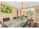 Bright dining room features a glass table, modern chandelier, and colorful art, perfect for entertaining and Gathering meals at 676 Dunblane Dr, Winter Park, FL 32792