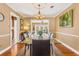 Elegant dining room with a glass-top table, chandelier, and hardwood floors at 676 Dunblane Dr, Winter Park, FL 32792