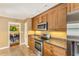 The renovated kitchen boasts wood cabinets, granite countertops, and stainless steel appliances and is close to the dining area at 676 Dunblane Dr, Winter Park, FL 32792