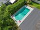 Aerial view of private backyard pool surrounded by lush landscaping and playful floaties at 676 Dunblane Dr, Winter Park, FL 32792
