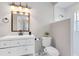 Modern bathroom with bronze fixtures, white cabinets and a mirror with overhead sconce lighting at 718 Glen Eagle Dr, Winter Springs, FL 32708