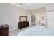 Neutral bedroom with a dark wood dresser, access to the ensuite bathroom, and plush blue bedding at 718 Glen Eagle Dr, Winter Springs, FL 32708