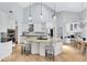 Open kitchen with an island, bar seating, pendant lights, and modern white cabinetry at 718 Glen Eagle Dr, Winter Springs, FL 32708
