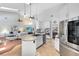 Spacious kitchen with white cabinets, stainless steel appliances, an island with granite countertops, and open to the living room at 718 Glen Eagle Dr, Winter Springs, FL 32708