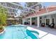 Relaxing screened pool with hot tub, summer kitchen, and ample seating area offers the ultimate outdoor retreat at 718 Glen Eagle Dr, Winter Springs, FL 32708