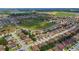 Aerial view of a residential area, featuring single-Gathering homes with green lawns and mature trees, close to a large green space at 731 Arbor Pointe Ave, Minneola, FL 34715