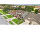 Aerial view of a charming two-story home featuring a red door, lush landscaping, and well-manicured lawns at 731 Arbor Pointe Ave, Minneola, FL 34715