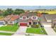 Aerial view of a beautiful two-story home with a red door, well-maintained landscaping, and green lawns at 731 Arbor Pointe Ave, Minneola, FL 34715