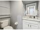A well lit half-bathroom has a white vanity with a large mirror and tile flooring at 731 Arbor Pointe Ave, Minneola, FL 34715