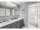 Bathroom featuring double vanity, decorative mirror and tiled tub surround at 731 Arbor Pointe Ave, Minneola, FL 34715
