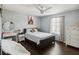 Bright bedroom with a ceiling fan, dark floors, and a cozy seating area at 731 Arbor Pointe Ave, Minneola, FL 34715