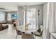 Stylish dining area with a marble-top table, gray chairs, and sheer curtains providing ample natural light at 731 Arbor Pointe Ave, Minneola, FL 34715