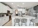 Modern kitchen with white cabinets, quartz countertops, stainless steel appliances, and a breakfast bar with seating at 731 Arbor Pointe Ave, Minneola, FL 34715