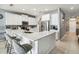 Modern kitchen with white cabinets, quartz countertops, stainless steel appliances, and a breakfast bar with seating at 731 Arbor Pointe Ave, Minneola, FL 34715