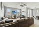 Bright living room connected to the dining area, featuring a large sectional sofa and a modern entertainment center at 731 Arbor Pointe Ave, Minneola, FL 34715