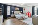Cozy main bedroom with tray ceiling, accent wall, wood floors and sitting area at 731 Arbor Pointe Ave, Minneola, FL 34715