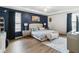 Stylish primary bedroom showcasing a decorative accent wall, tray ceiling and a sitting area at 731 Arbor Pointe Ave, Minneola, FL 34715
