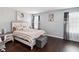 Charming bedroom with striped bedding, wood floors, and ample natural light at 731 Arbor Pointe Ave, Minneola, FL 34715