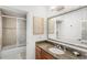 Bright bathroom featuring granite counters, a tiled shower with glass door and a large mirror at 7650 Whisper Way # 104, Reunion, FL 34747