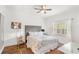 Well-lit bedroom features a tufted headboard, hardwood floors, and a large window at 7650 Whisper Way # 104, Reunion, FL 34747