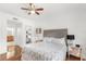 Bedroom features a tufted headboard, hardwood floors, and view into the ensuite bathroom at 7650 Whisper Way # 104, Reunion, FL 34747