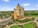 Stunning aerial view of a golf resort featuring a modern hotel, clubhouse and beautiful landscaping at 796 Desert Mountain Ct, Reunion, FL 34747