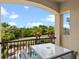 Cozy balcony with comfortable furniture and a view of the lush green landscape, swimming pool, and blue skies at 796 Desert Mountain Ct, Reunion, FL 34747