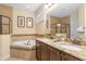 Bathroom showcasing double sinks, granite countertops, a soaking tub and a tile-enclosed shower at 796 Desert Mountain Ct, Reunion, FL 34747