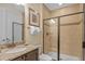 Well-lit bathroom featuring granite countertops, a dark wood vanity, a shower with glass doors, and neutral tile at 796 Desert Mountain Ct, Reunion, FL 34747