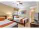 Cozy bedroom featuring two beds, soft lighting, decorative pillows, and an attached bathroom with a glass door shower at 796 Desert Mountain Ct, Reunion, FL 34747