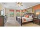 Bright bedroom with tray ceilings features neutral colors, carpet floors, and three windows with patterned valances at 796 Desert Mountain Ct, Reunion, FL 34747