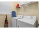 Well-lit laundry room featuring modern appliances and ample shelving for storage solutions at 796 Desert Mountain Ct, Reunion, FL 34747