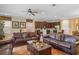 Inviting living room featuring leather sofas, a decorative rug, and an open layout connecting to the kitchen and dining area at 796 Desert Mountain Ct, Reunion, FL 34747