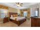 Comfortable main bedroom featuring a king-size bed, a ceiling fan, side tables, and natural light from the windows at 796 Desert Mountain Ct, Reunion, FL 34747