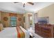 Spacious bedroom with a king bed, side tables, dresser with TV, and access to a private outdoor balcony at 796 Desert Mountain Ct, Reunion, FL 34747
