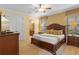 Cozy main bedroom with plush bedding, side tables, and an ensuite bathroom with tile flooring at 796 Desert Mountain Ct, Reunion, FL 34747