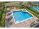 An inviting pool area with a spa, lounge chairs, a fire pit, and lush landscaping, perfect for relaxation and entertainment at 796 Desert Mountain Ct, Reunion, FL 34747