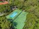 Aerial view of dual tennis courts surrounded by lush, mature trees offering a private recreation space at 8507 Crystal Cove Loop, Kissimmee, FL 34747