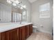 Bathroom features a wood vanity with a white sink, toilet, and shower with curtain at 8531 Cypress Hollow Ct, Sanford, FL 32771