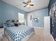This bedroom offers a ceiling fan, a bed with storage, and blue walls at 8531 Cypress Hollow Ct, Sanford, FL 32771
