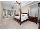 The main bedroom has high ceilings with a canopy bed, dark wood furniture, and lots of natural light at 8531 Cypress Hollow Ct, Sanford, FL 32771