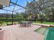 Screened-in patio features brick pavers, outdoor dining set, and a sparkling swimming pool with attached spa at 8531 Cypress Hollow Ct, Sanford, FL 32771