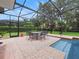 Covered patio with pool, brick pavers, seating, and string lights, perfect for outdoor entertaining and relaxation at 8531 Cypress Hollow Ct, Sanford, FL 32771