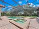 Backyard pool and attached spa feature brick pavers, waterfall features, and lush green lawn at 8531 Cypress Hollow Ct, Sanford, FL 32771