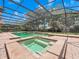 Backyard pool and attached spa feature brick pavers, waterfall features, and lush green lawn at 8531 Cypress Hollow Ct, Sanford, FL 32771